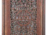 a carved wood panel with an oriental design on it