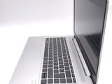 a silver laptop with a black keyboard on a white surface
