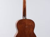 an acoustic guitar hanging from the back of a white wall