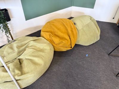 trois poufs posés par terre devant un tableau noir