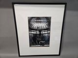 a picture of a bird in a cage hanging on a wall