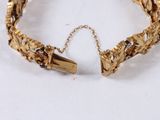 gold tone bracelet with multi colored stones and a gold chain
