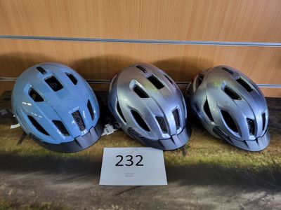 trois casques sont alignés sur une étagère à côté d'un panneau