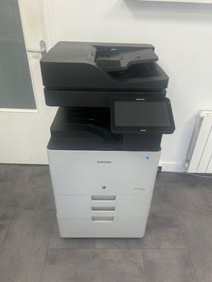 a black and white printer sitting on top of a white cabinet