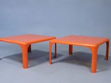 une paire de tables d'appoint en plastique orange sur fond gris