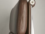 brown leather office chair with arm rest and button on the back of the chair