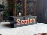 a wooden sign that says scotch on it sitting on a table