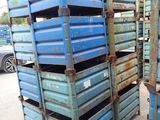 many blue crates stacked on top of each other in a parking lot