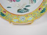 a plate with a painting on it sitting on a table