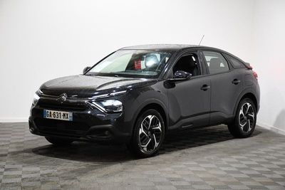 Le SUV noir est garé dans une pièce dont le sol est en damier.