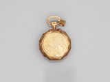 a close up of a gold pocket watch on a white surface