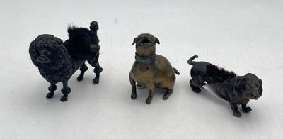 three figurines of dogs standing in the snow