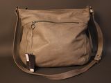 leather shoulder bag with zippers and a strap on a dark background