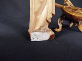 a statue of a woman with a bird on a cart