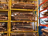 de nombreuses piles de bois dans un entrepôt, posées sur des palettes