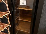 a black refrigerator with a glass door next to a stack of shelves
