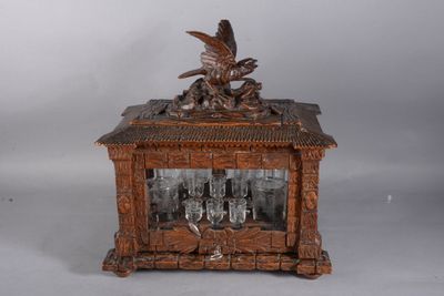 une horloge en bois surmontée d'un oiseau