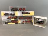 plein de petits trains miniatures dans une boîte posée sur la table