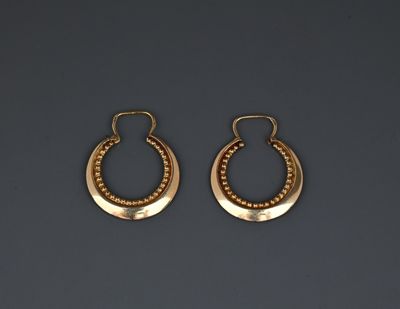 a pair of gold hoop earrings with beaded details