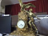 a statue of a man holding a clock on a desk