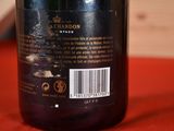 a bottle of wine sitting on a table with a red cloth