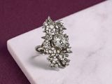 une photo d'une bague en diamant posée sur une dalle de marbre
