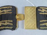 gold and black belt with a gold buckle on a white surface