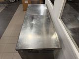 a stainless steel counter in the middle of a room