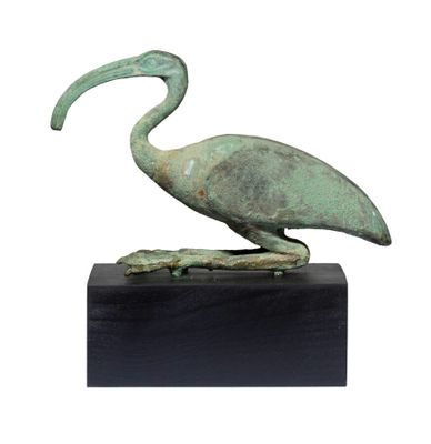 statue représentant un oiseau sur un socle noir, avec un fond blanc