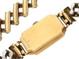 a gold watch with a chain around it on a white surface