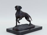 a bronze statue of a dog standing on top of a black base