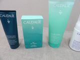 three bottles of caudalie and a tube of lotion sitting next to each other