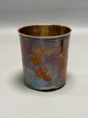 a silver cup with a red and blue design on it