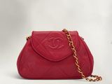un sac Chanel rouge auquel est suspendue une chaîne