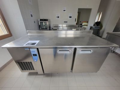 plan de travail en acier inoxydable dans une cuisine commerciale équipée d'appareils en acier inoxydable