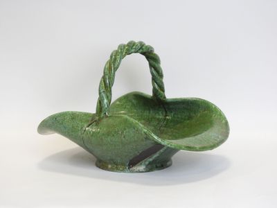 an image of a green ceramic basket with a handle on a white background