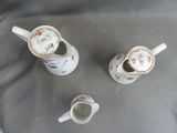 three cups and a saucer sitting on a table