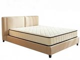 the bed frame is made of beige fabric and has a mattress on it