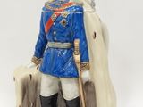 une figurine représentant un homme en uniforme bleu, muni d'une épée