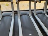 three tread machines are lined up in a row in a gym