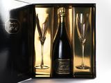 two champagne glasses and a bottle of wine in a black box