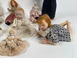 a lot of dolls that are sitting on a white surface