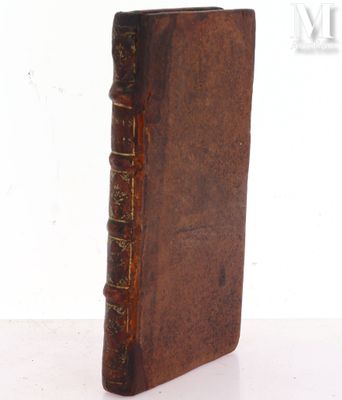 an old book sitting on top of a table next to a white wall