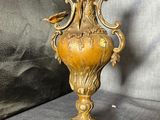 a gold vase sitting on a table with a black background