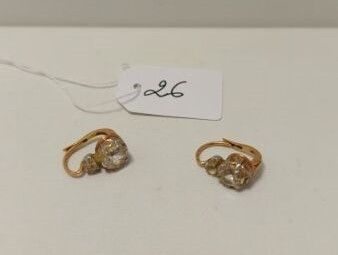 deux paires de boucles d'oreilles en or posées sur une surface blanche, avec une étiquette de prix