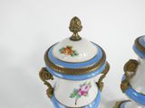 pair of blue and white vases with flowers on them on a white surface