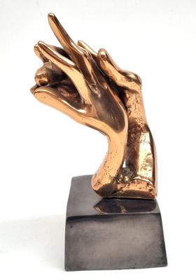 statue représentant une main dont un doigt est levé, posée sur un socle noir