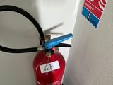 un extincteur fixé au mur à côté d'une borne d'incendie