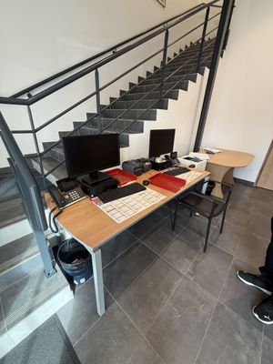 un homme debout devant un bureau sur lequel se trouve un ordinateur