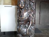 a statue of a woman sitting on top of a fireplace